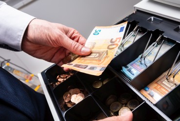 Man taking European currency out of a cash register