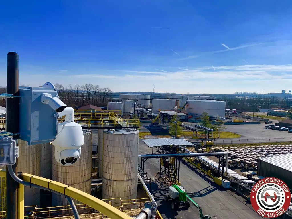 A Pan-Tilt-Zoom camera installed on a tall pole overlooking an industrial facility