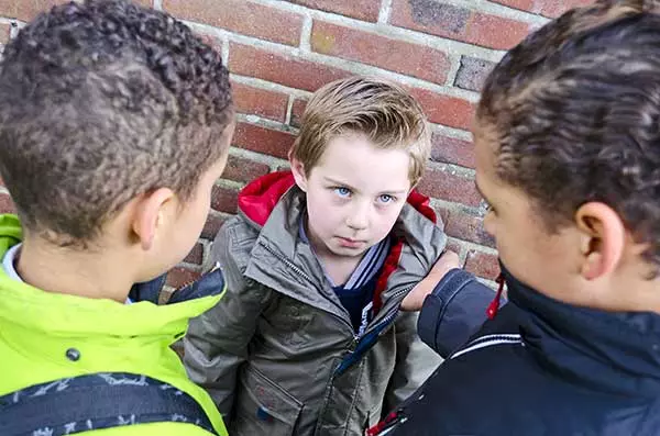 Two kids bullying a kid much smaller than they are