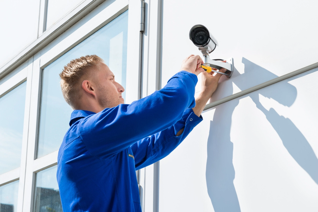 Security camera installation technician working on a commercial property