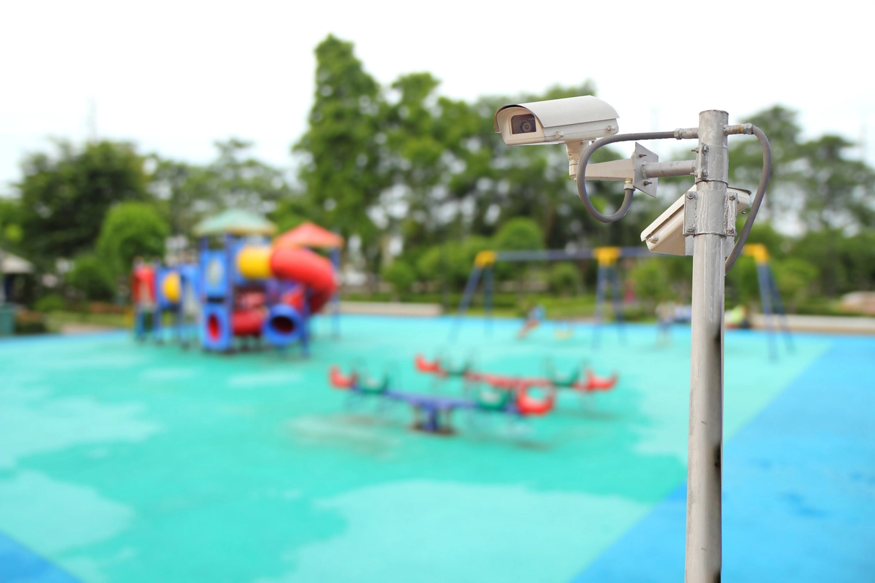 technician installing outdoor security camera at school athletic field