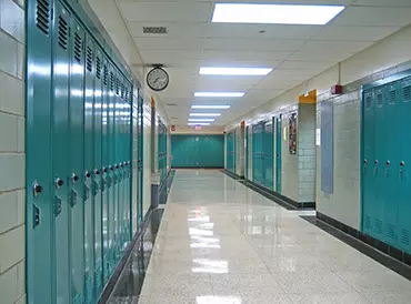 An empty school hallway, with lockers lining both sides
