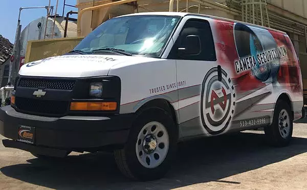 A Camera Security Now work van in front of heavy machinery at a gravel pit